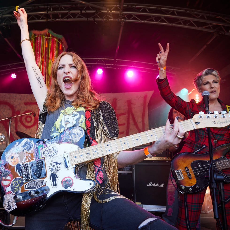 Band performing on stage with electric guitars and vibrant lighting