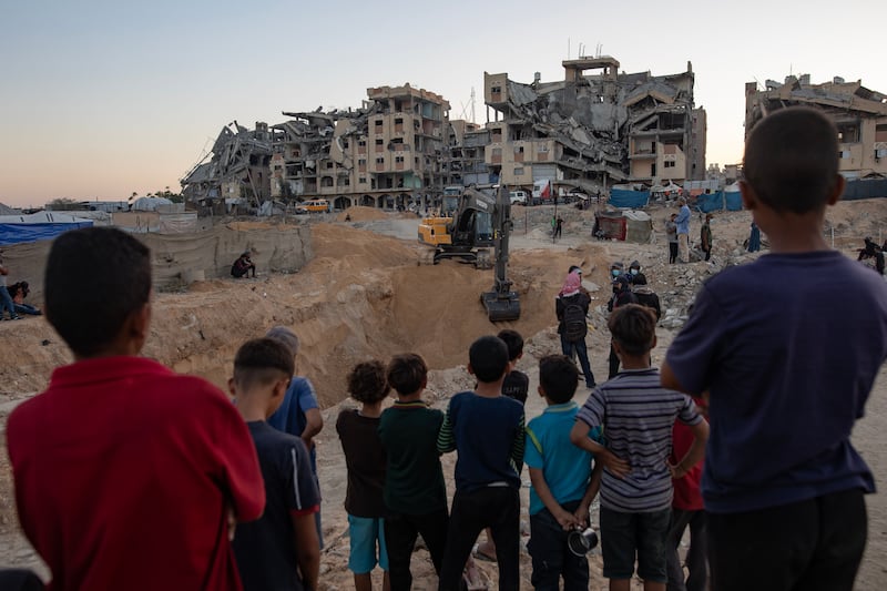 Palestinians watch as machinery and workers from Egypt search the rubble of damaged buildings for the bodies of hostages in the Hamad City area of Khan Yunis, southern Gaza Strip. Photograph: Haitham Imad/EPA
