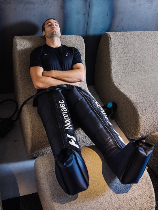 Gym member using compression boots in the recovery lounge at Animo Studios