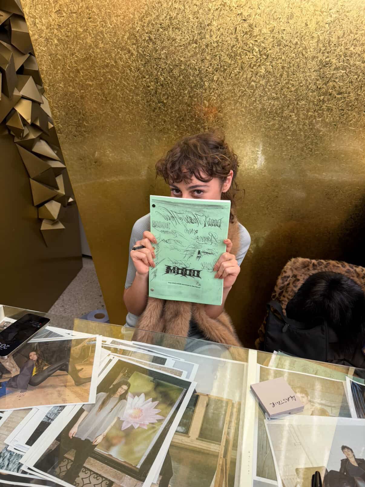 Petronio holding up a copy of her Anne Imhofs Doom Documented by Tess Petronio at the book's launch at Dover Street...
