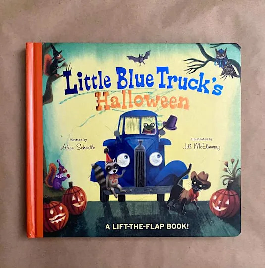 Children's book cover featuring a blue truck with animals in Halloween costumes, pumpkins, and bats.