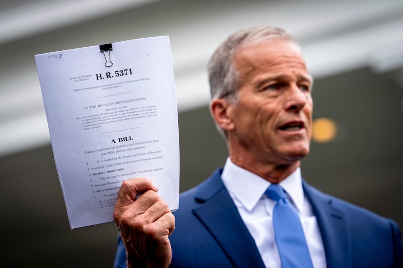 Senate majority leader John Thune holds the Republican spending Bill as he speaks to reporters after meeting president Donald Trump. Photograph: Doug Mills/The New York Times
                      