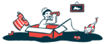 A child wearing a sailor hat sits in a box and holds a toy fishing pole.