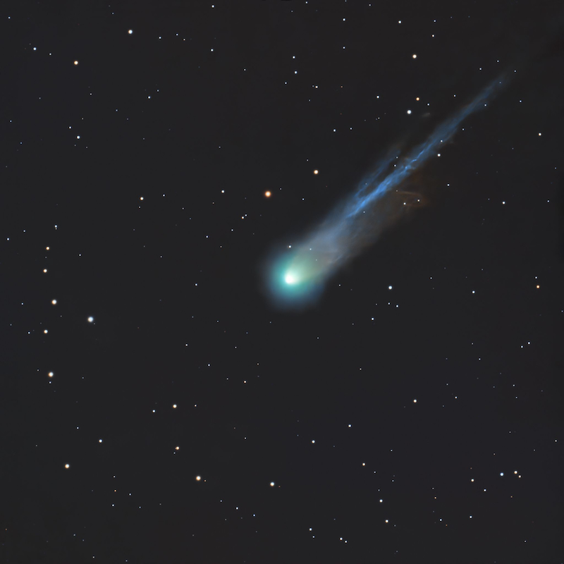 Fuzzy glowing ball in a starfield with a multi-stranded long tail.