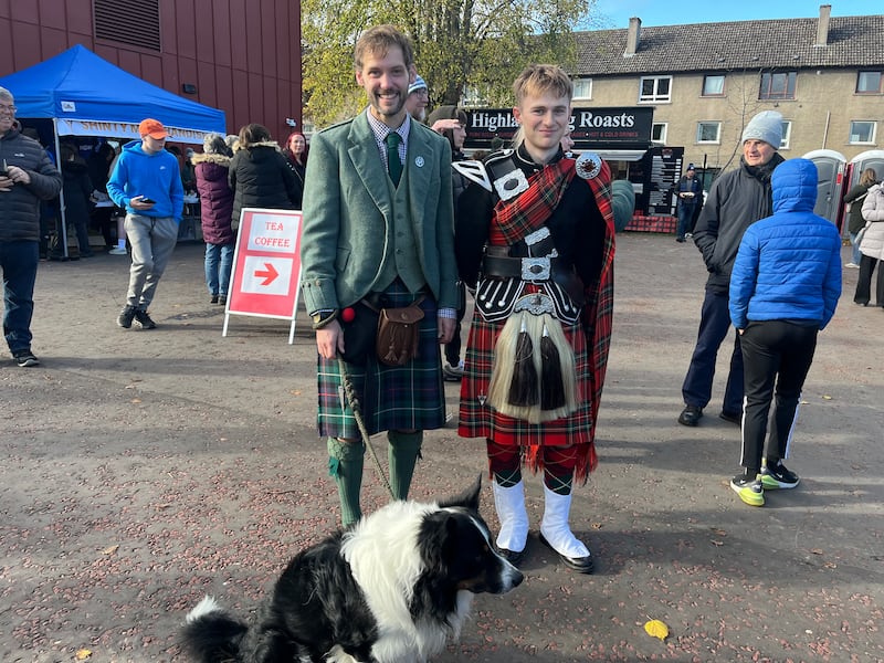 Two local men with Sonas the dog watching the shinty-hurling at Bught Park in Inverness