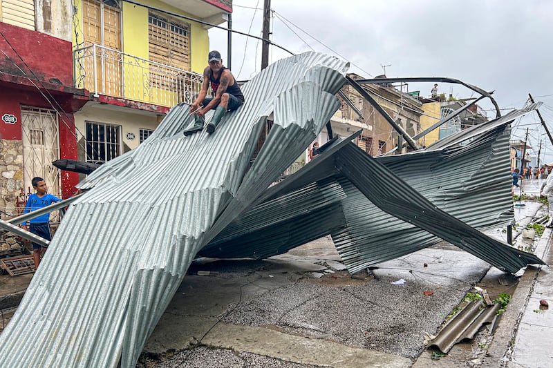 A resident sits on part of the roof of his house, damaged by Hurricane Melissa, in Santiago de Cuba, eastern Cuba, on Wednesday. Photograph: Yamil Lage/AFP via Getty Images