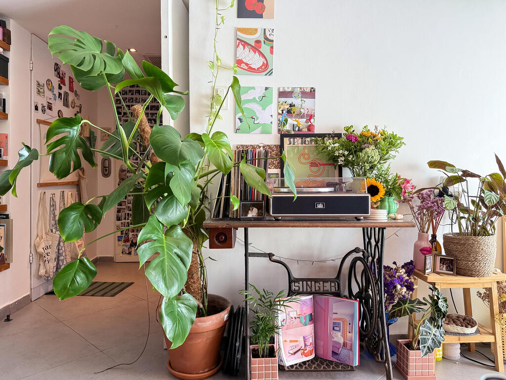 A record player and vinyls rest on an old sewing machine  (Photo: Noam Ron)  הדירה של אביב ונדב, מדור כאן גרים