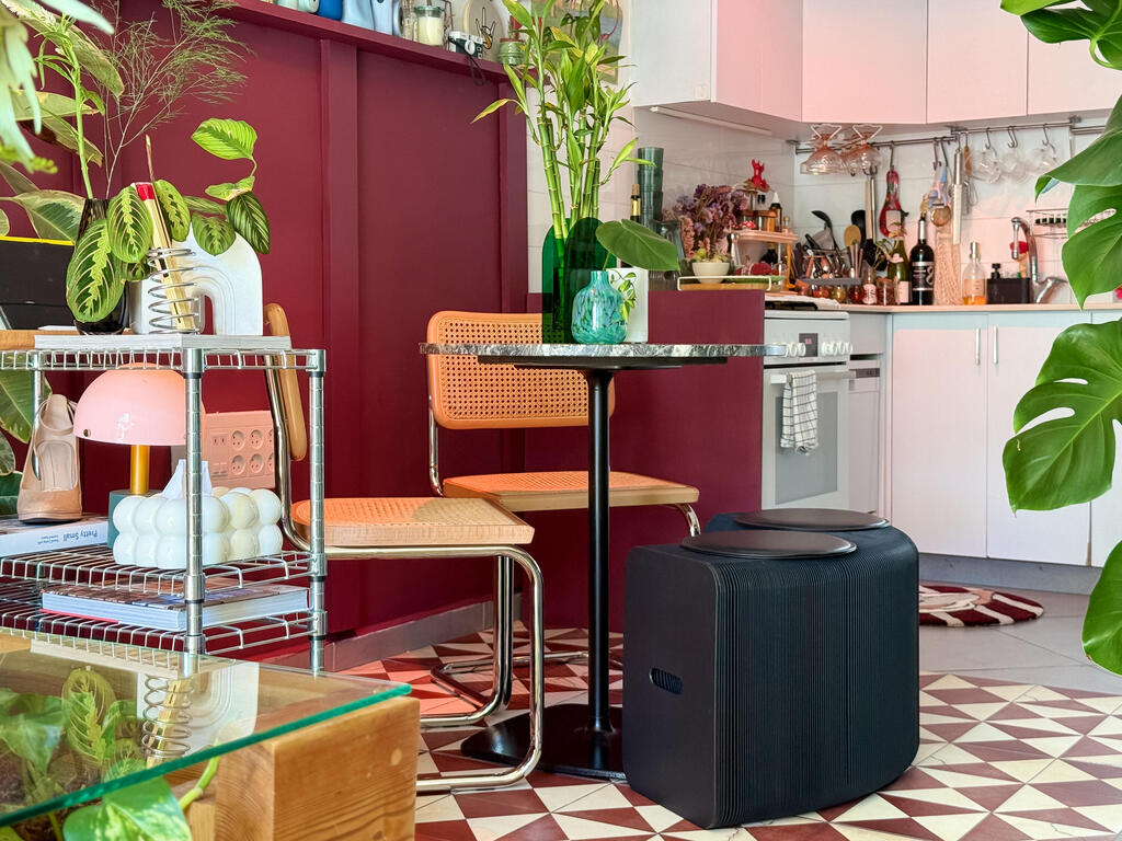 The dining area sits between the white kitchen and the colorful living room  (Photo: Noam Ron)  הדירה של אביב ונדב, מדור כאן גרים