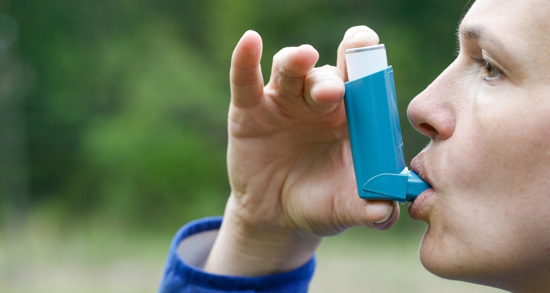 Asthma patient inhaling medication for treating shortness of breath and wheezing