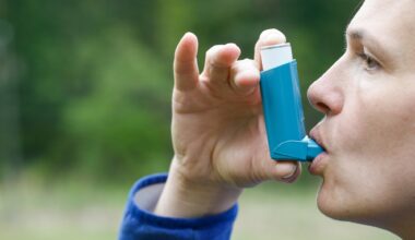 Asthma patient inhaling medication for treating shortness of breath and wheezing