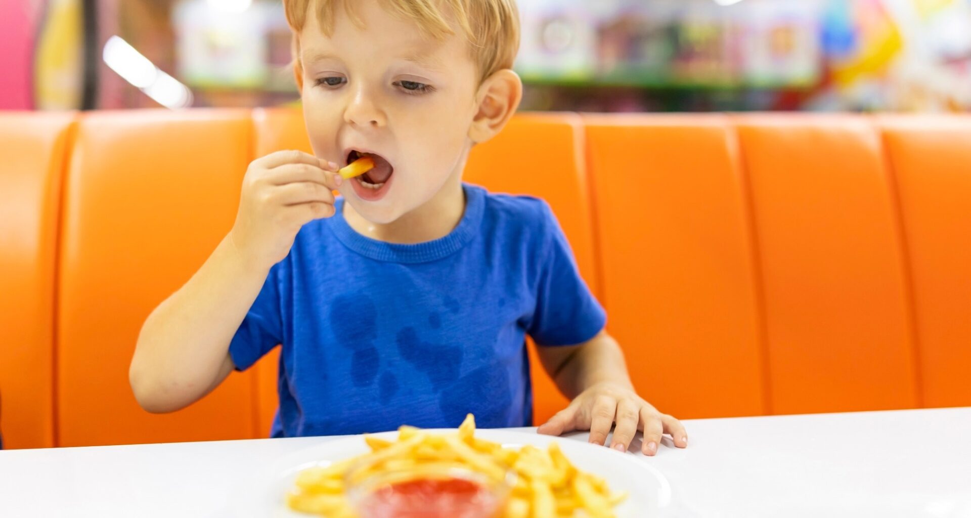 child eating french fries with sauce