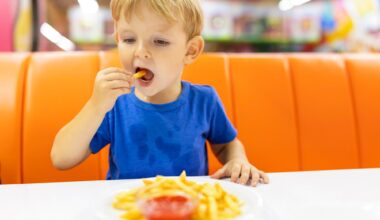 child eating french fries with sauce