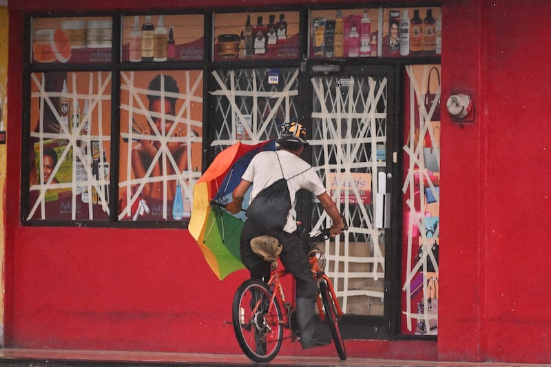 A cyclist seeks shelter from Hurricane Mellisa in Portmore, Jamaica. Photograph: RICARDO MAKYN/AFP via Getty Images