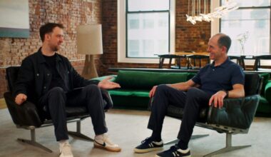 Keith Rabois and Scott Stevenson sit on low, comfortable chairs in an office, talking.