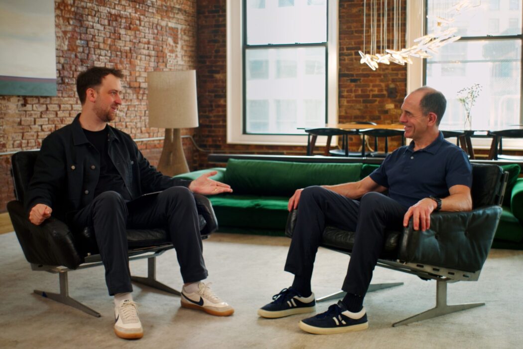 Keith Rabois and Scott Stevenson sit on low, comfortable chairs in an office, talking.