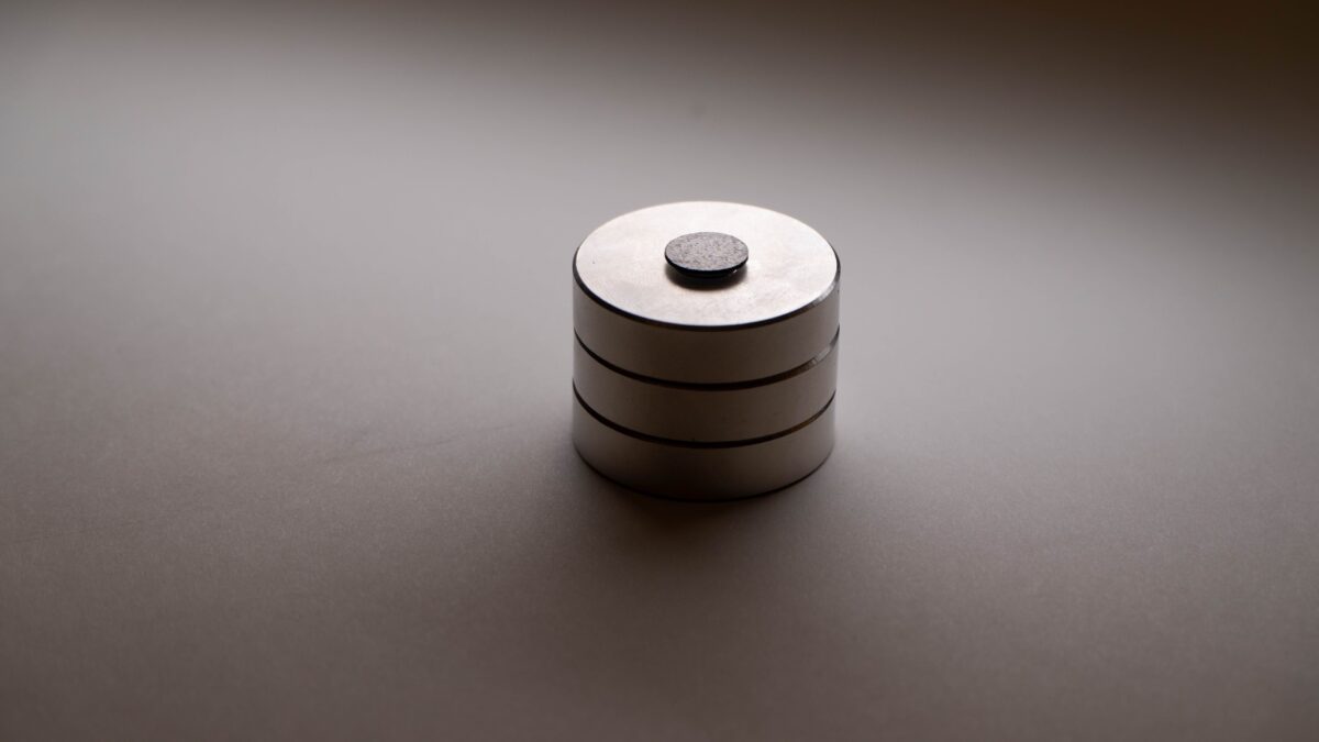The black graphite disk floats above a stack of three, round magnets.