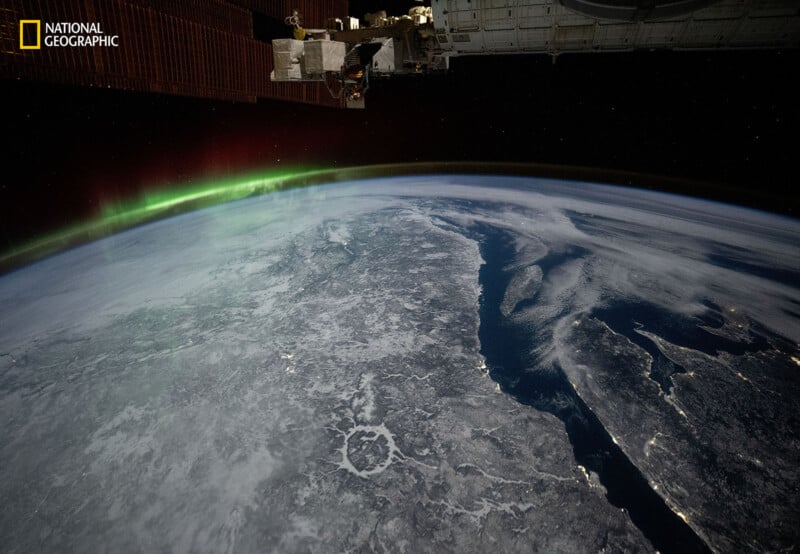 A view of Earth from space shows icy land, bodies of water, and green auroras near the horizon; part of a spacecraft is visible at the top. The National Geographic logo appears in the top left corner.
