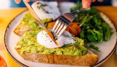 Person eating avocado toast with poached egg and salmon, close-up view