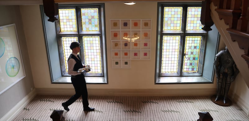 Staff member Jude McCarthy walks by art in the Park Hotel Kenmare. 