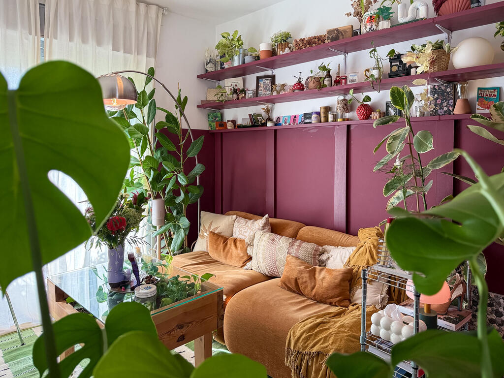 A duet of burgundy and mustard: the living room. (Photo: Noam Ron)  הדירה של אביב ונדב, מדור כאן גרים