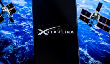 Starlink logo on a screen with planet and satellites in background