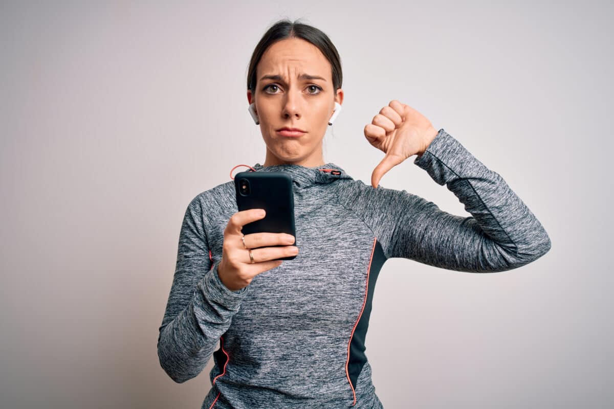 Woman giving thumbs down to smartphone