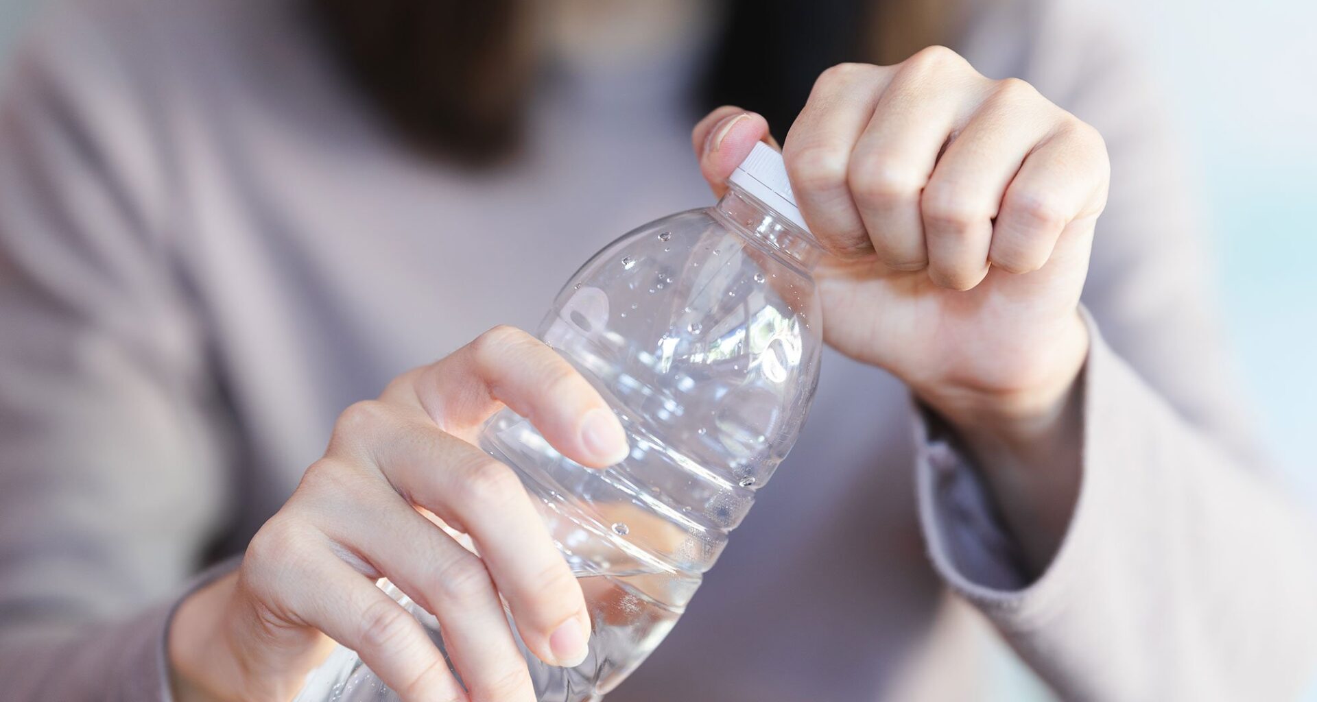 Woman Opening Plastic Water Bottle