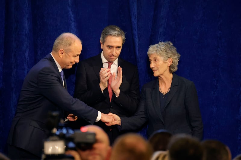 Catherine Connolly is congratulated by Taoiseach Micheál Martin and Tánaiste Simon Harris on stage at Dublin Castle. Photograph: Alan Betson