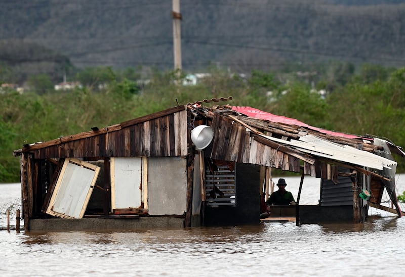 A farmer remains inside his flooded house after the passage of Hurricane Melissa through the Cuban town of San Miguel de Parada in Santiago de Cuba province on Wednesday. Photograph: by Yamil Lage/AFP via Getty Images          