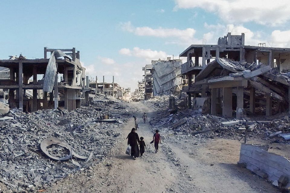 A drone view shows people walking through a destroyed residential neighbourhood following the withdrawal of the Israeli forces from the area, amid a ceasefire between Israel and Hamas in Gaza yesterday. Photo: Dawoud Abu Alkas/Reuters