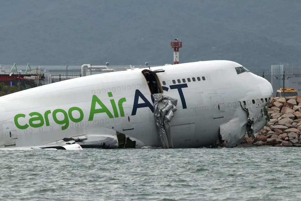 A cargo plane lies partially in the sea after veering off the runway during landing at Hong Kong International Airport in Hong Kong Photos: Reuters/Tyrone Siu