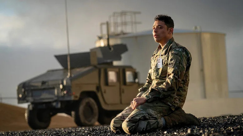 Major Daniel Gonzalez kneels in front of a military truck in "A House of Dynamite"
