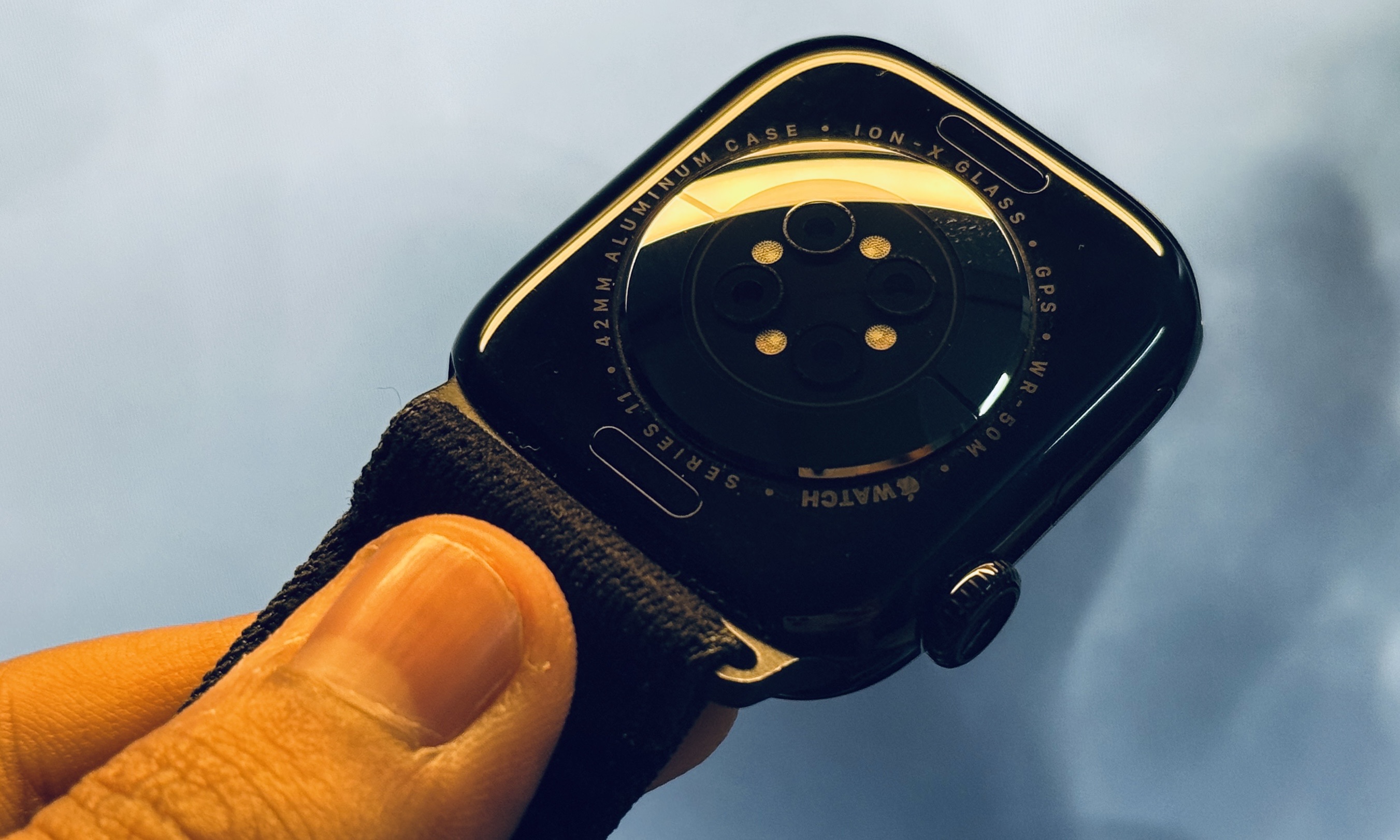 Holding Apple Watch Series 11 in the hand.