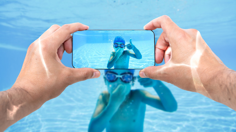 A person taking an underwater photo of a child
