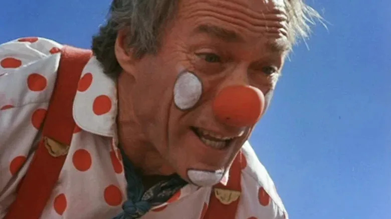 Tommy Nowak (Clint Eastwood) crouches wearing a clown outfit in Pink Cadillac