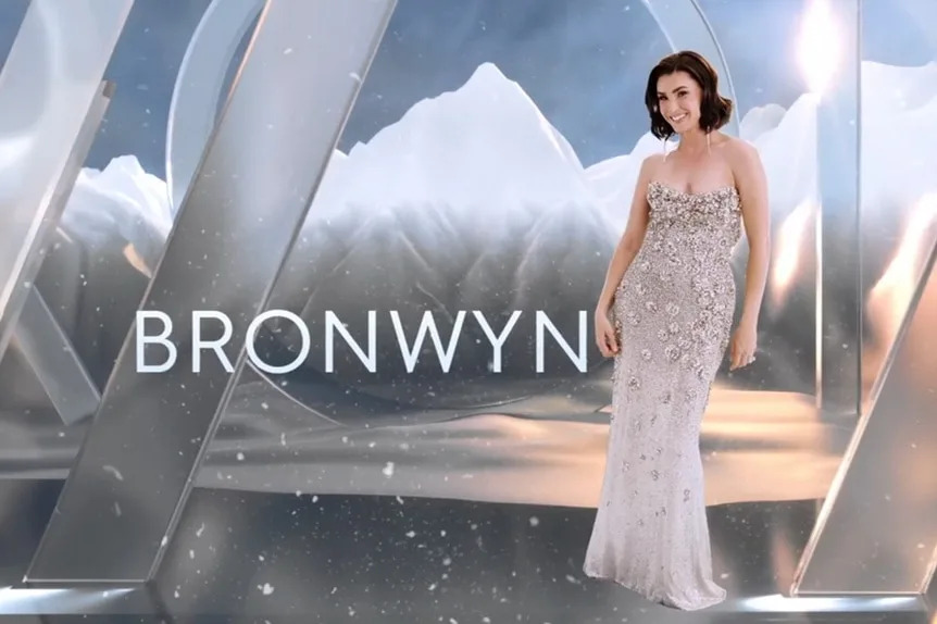 Bronwyn Newport wearing a silver sequin dress in front of a mountain and cloud graphic