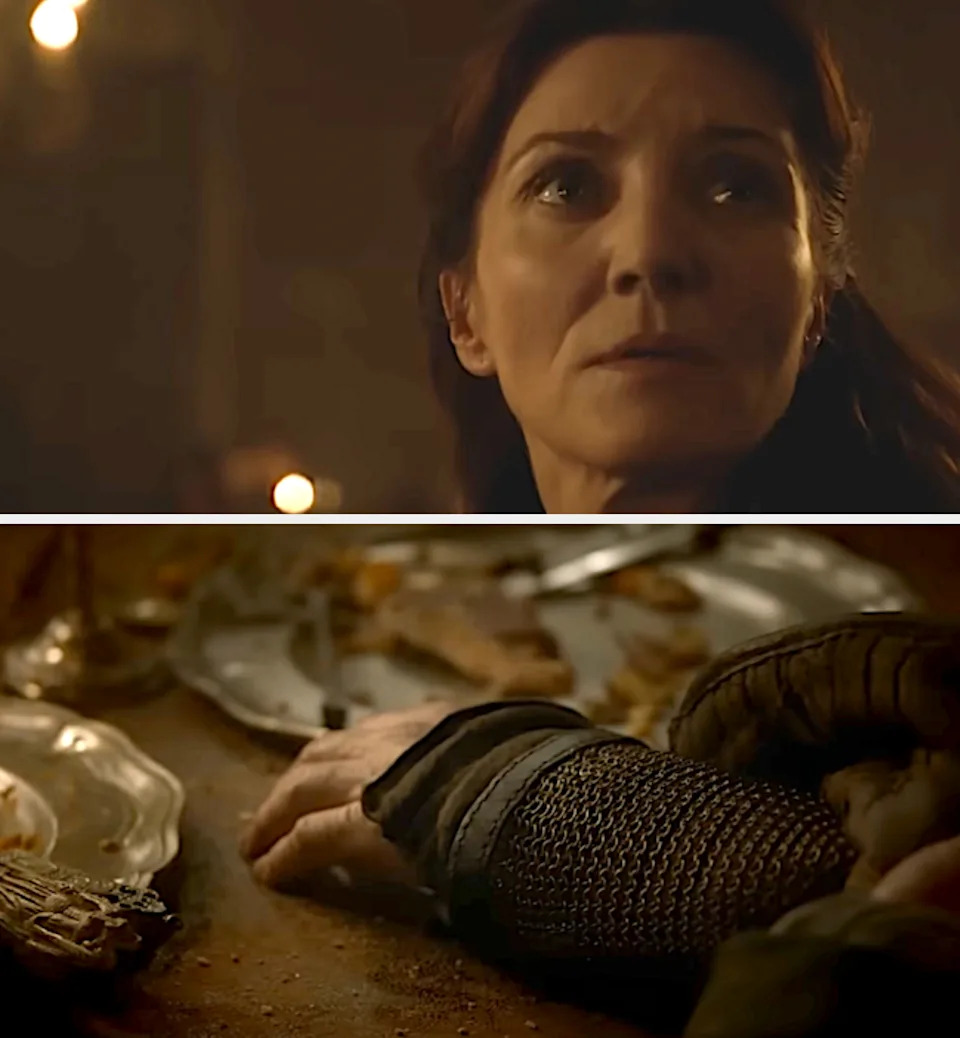 A dramatic scene from a medieval-themed show. A woman looks up solemnly, with a banquet table and armored arm below