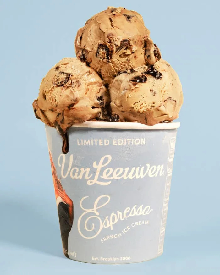 Three scoops of espresso-flavored ice cream with chocolate chunks in a Van Leeuwen cup