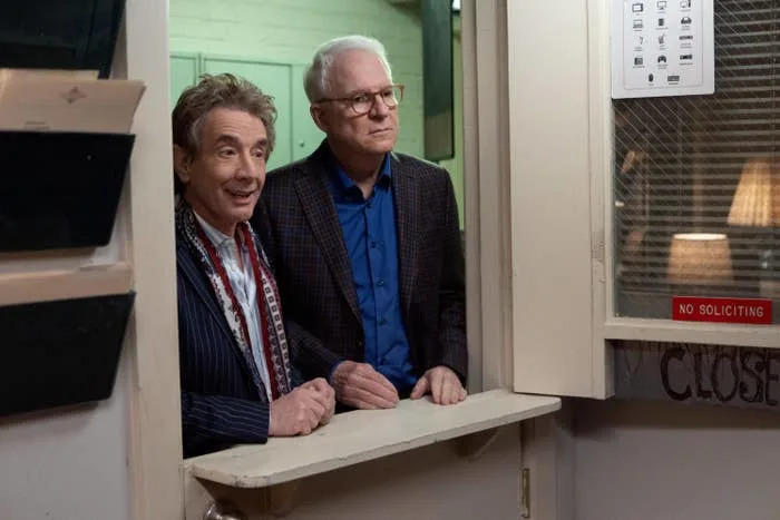 Martin Short and Steve Martin stand at a service counter, looking out