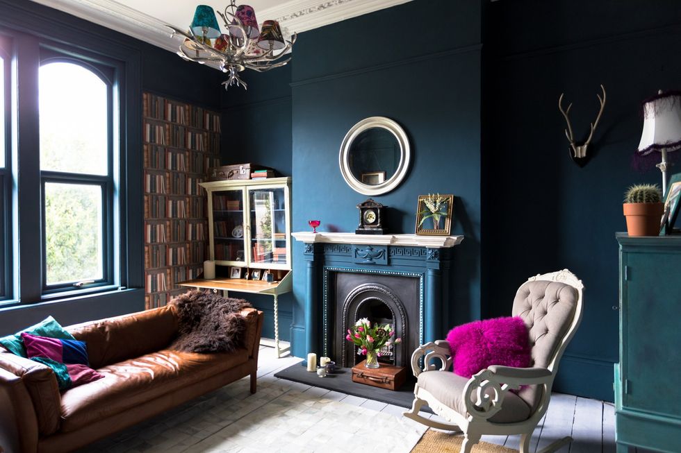 Cosy living room with rich colours, blue walls and purple cushions
