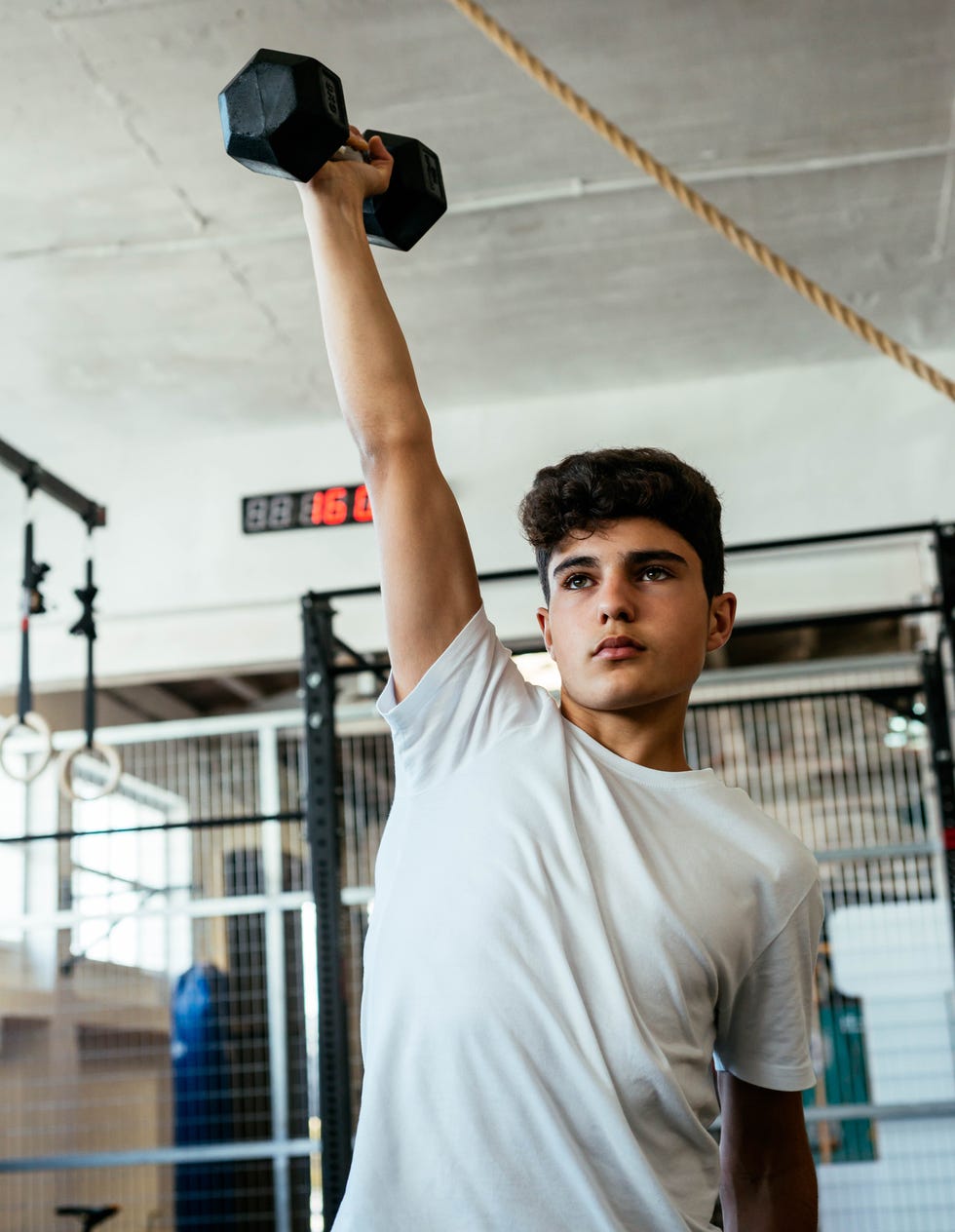 person lifting a dumbbell in a gym setting