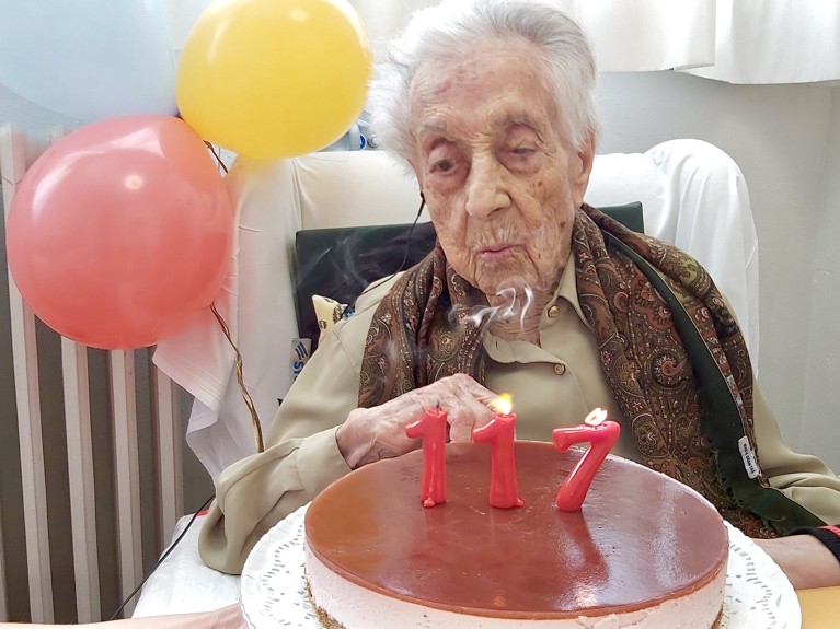 Portrait of Maria Branyas Morera blowing out candles on a cake at her 117th birthday.