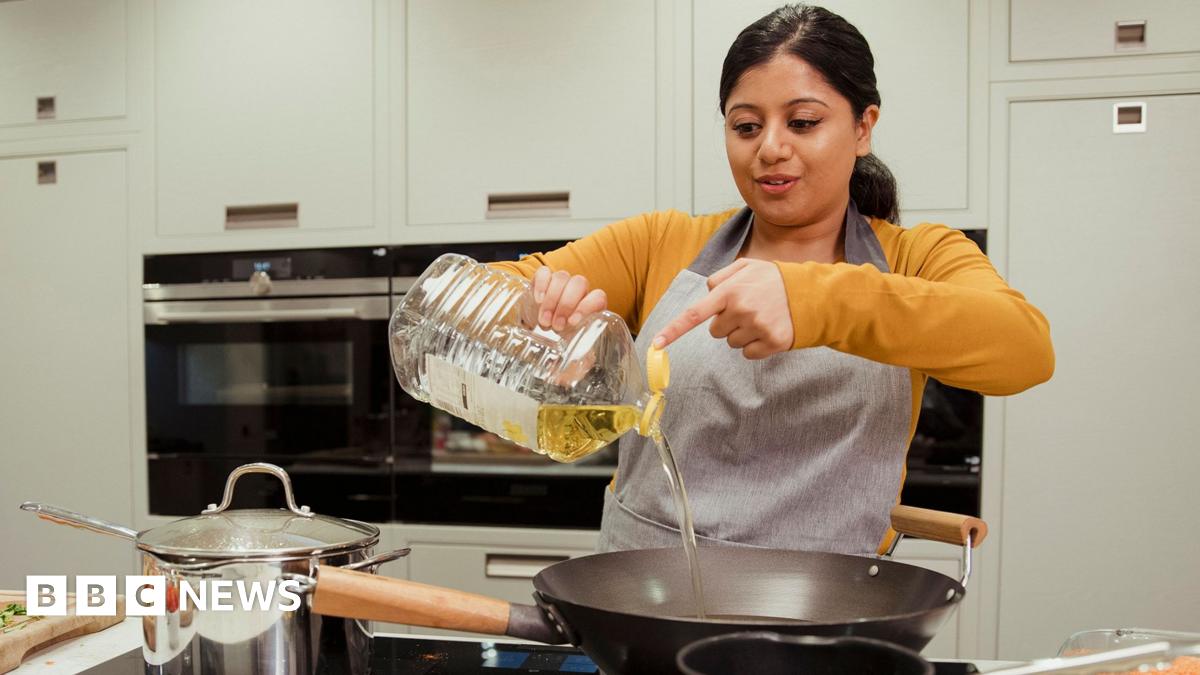 Assorted healthy vegetable oil bottle collection on wooden table in a old fashioned kitchen with low key illumination: Olive oil, hazelnut oil, almond oil, coconut oil and sesame oil