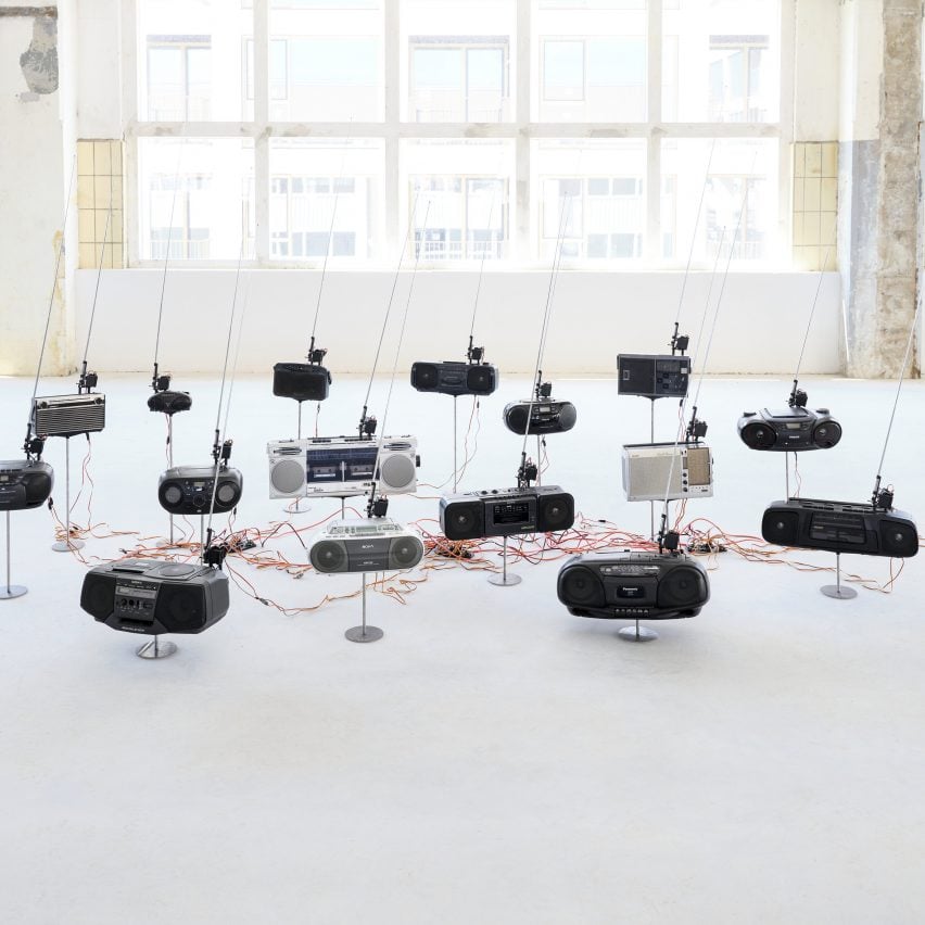 Photo of the How to Catch the Fire Dragon installation by Kai-Hsiang Wen showing a dozen or so radios with their antennas up and curving to the right
