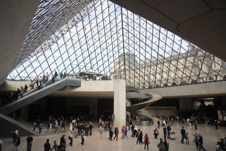 Visitors walk in the lobby of the Louvre museum three days after historic jewels were stolen in a daring daylight heist. Photo: Thibault Camus/AP