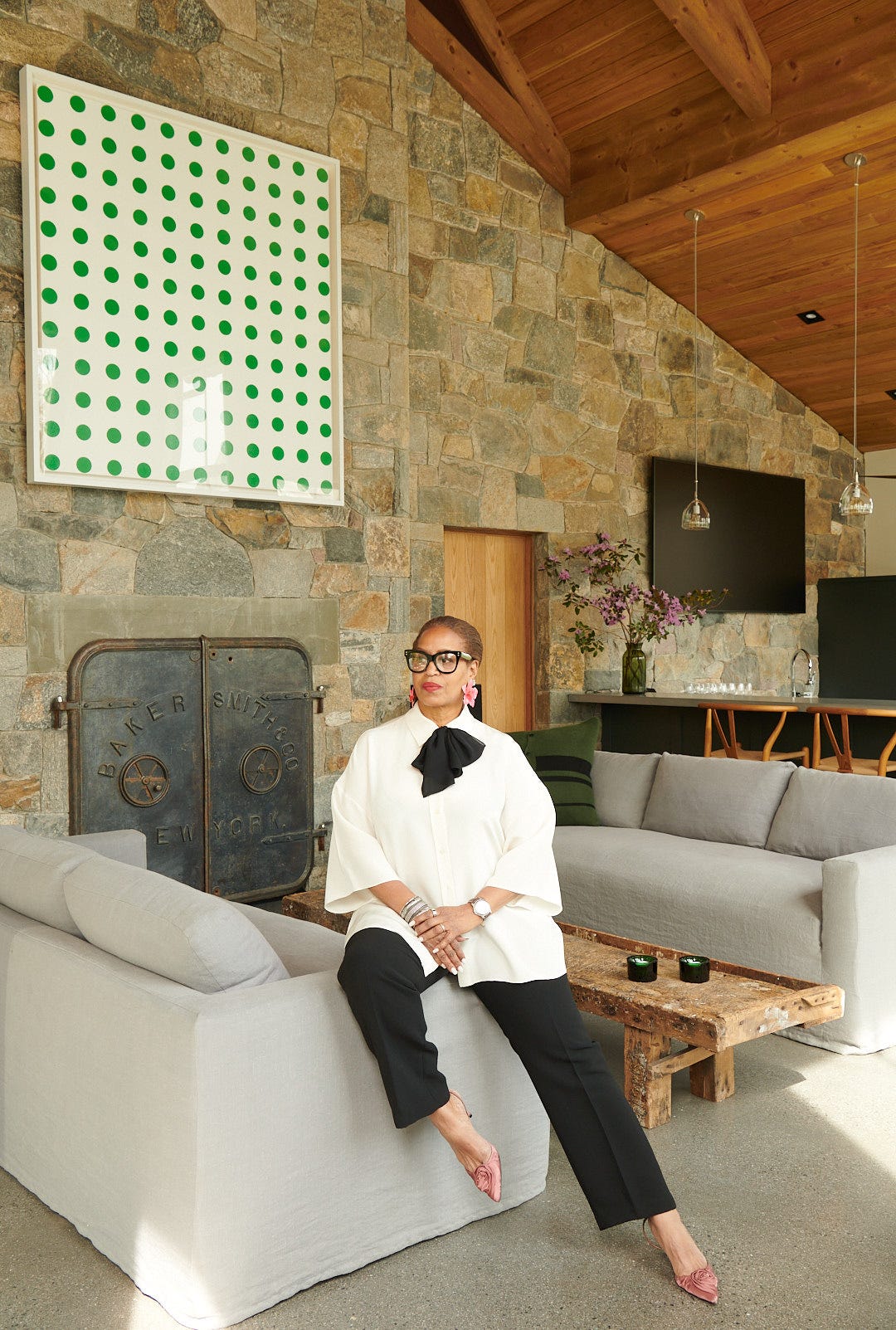 a stylish living room with modern decor and a person seated in contemporary attire