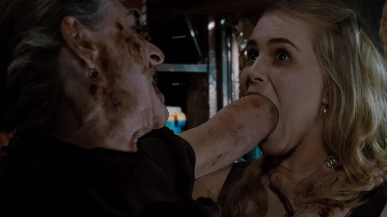 Lorna Raver as Mrs. Ganush sticks her arm in Alison Lohman as Christine Brown's mouth in Drag Me to Hell