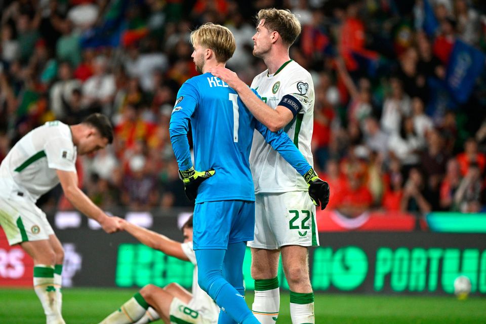 Ireland goalkeeper Caoimhín Kelleher and Ireland's Nathan Collins (right) look dejected with team-mates following defeat in the World Cup qualifying match at the Jose Alvalade Stadium, Lisbon