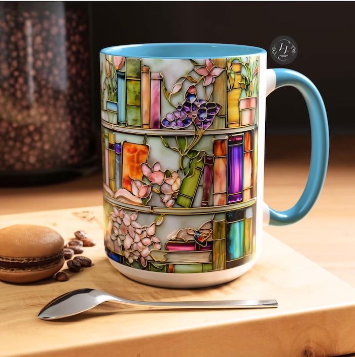 a coffee mug with a faux stained glass design of three rows of bookshelves adorned with flowers