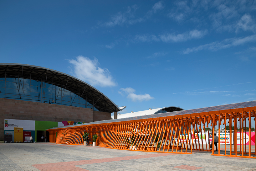 nudes' flow pavilion forms sinuous steel-pipe bridge between two exhibition halls in india